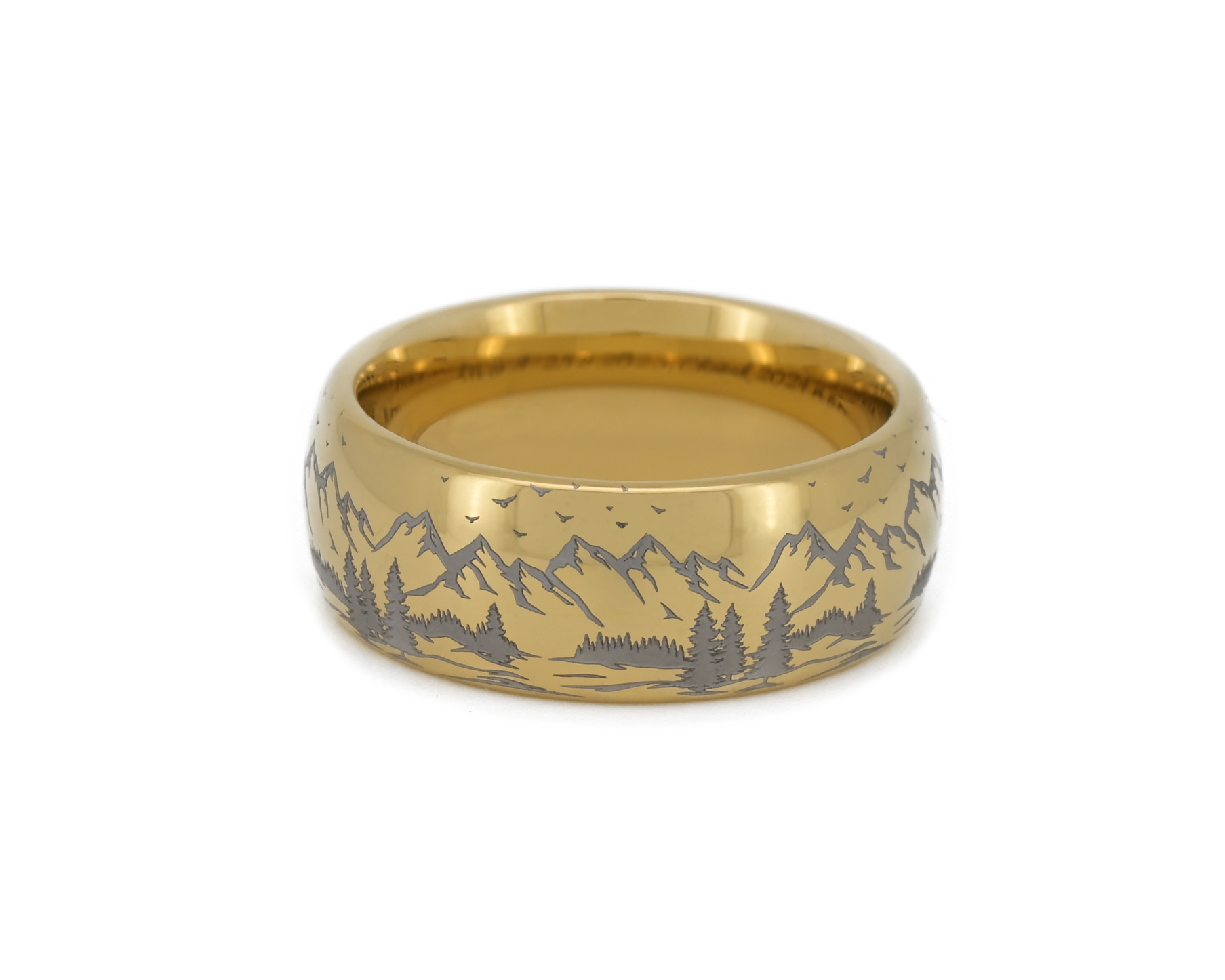 Gold tungsten ring with engraved mountain landscape design on a white background.