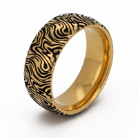 Product photo of the Golden Mokume Majesty tungsten ring with laser-engraved surface detail.
