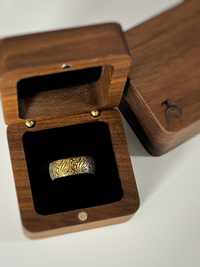 Product photo of the Golden Mokume Majesty tungsten ring with laser-engraved surface detail.