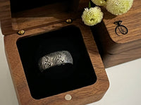 Product photo of the White Gold Mokume Majesty tungsten ring with laser-engraved surface detail.