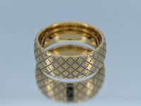 Product photo of the Golden Quilted Elegance tungsten ring with laser-engraved surface detail.