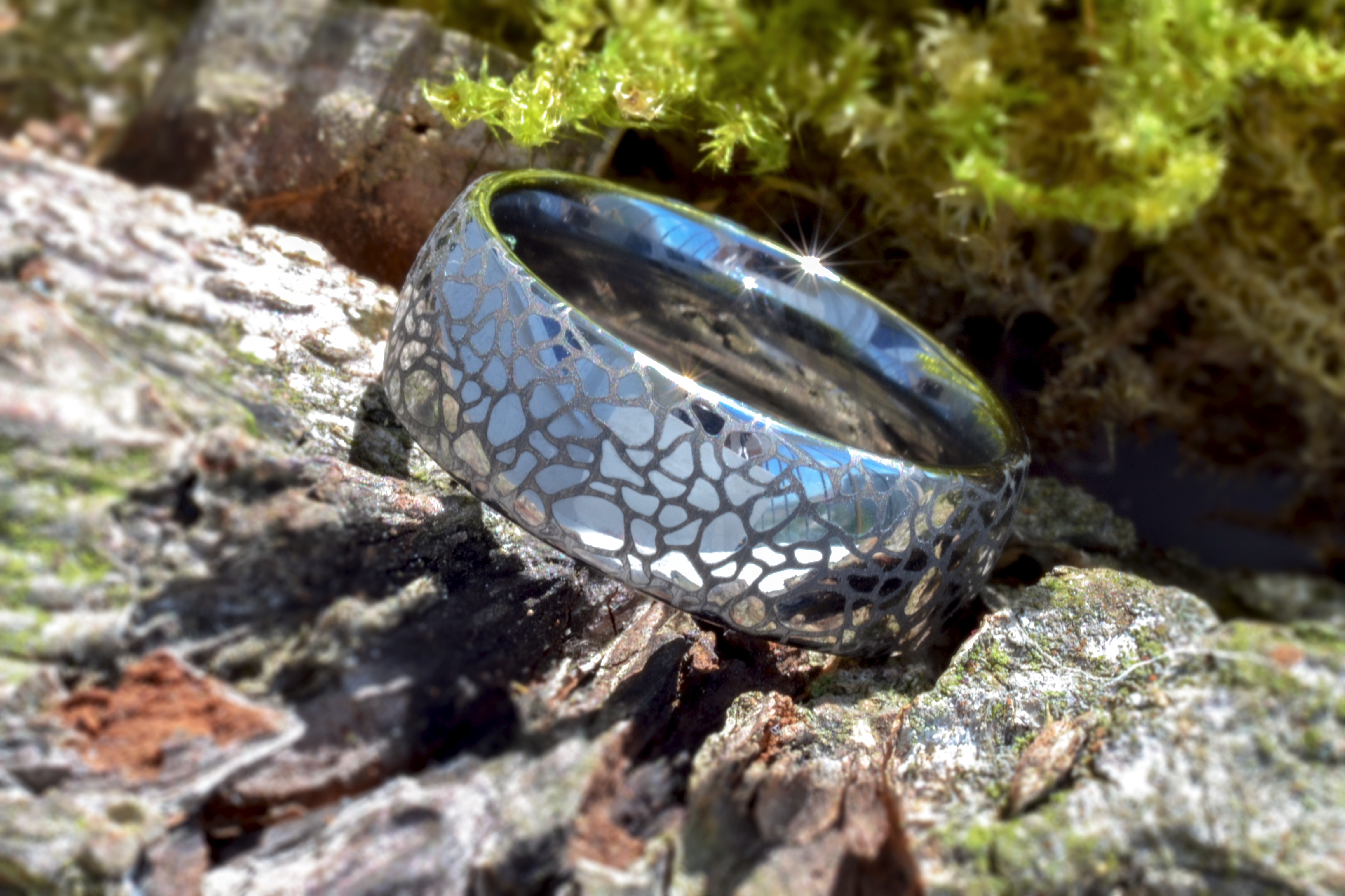 White gold tungsten ring with a cracked earth pattern, isolated on a white background.