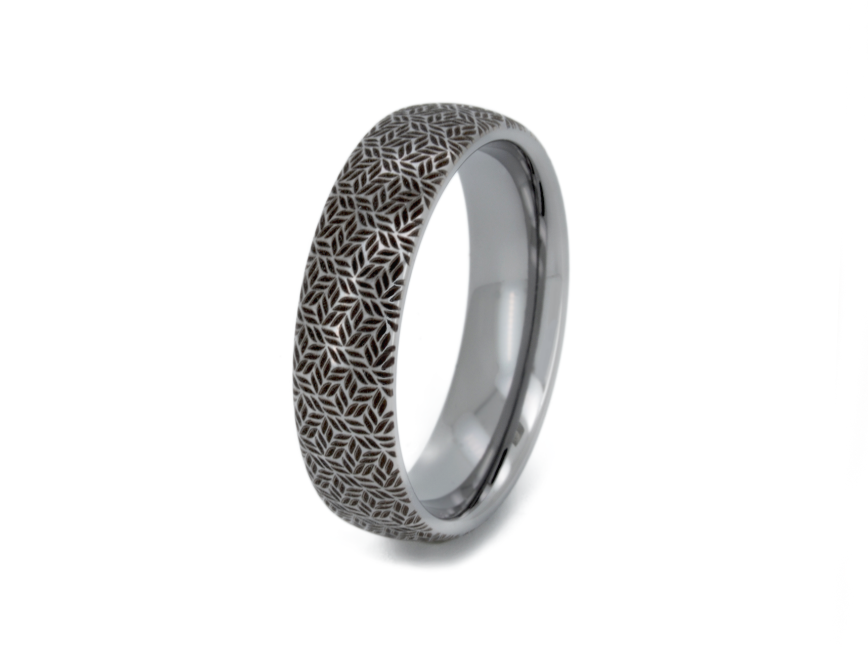 Silver tungsten ring with an intricate leaf pattern, isolated on a white background.