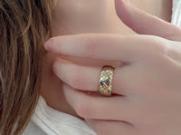 Product photo of the Golden Quilted Elegance tungsten ring with laser-engraved surface detail.