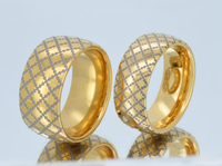 Product photo of the Golden Quilted Elegance tungsten ring with laser-engraved surface detail.