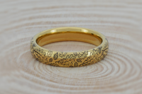 Product photo of the Delicate Oak Leaf tungsten ring with laser-engraved surface detail.