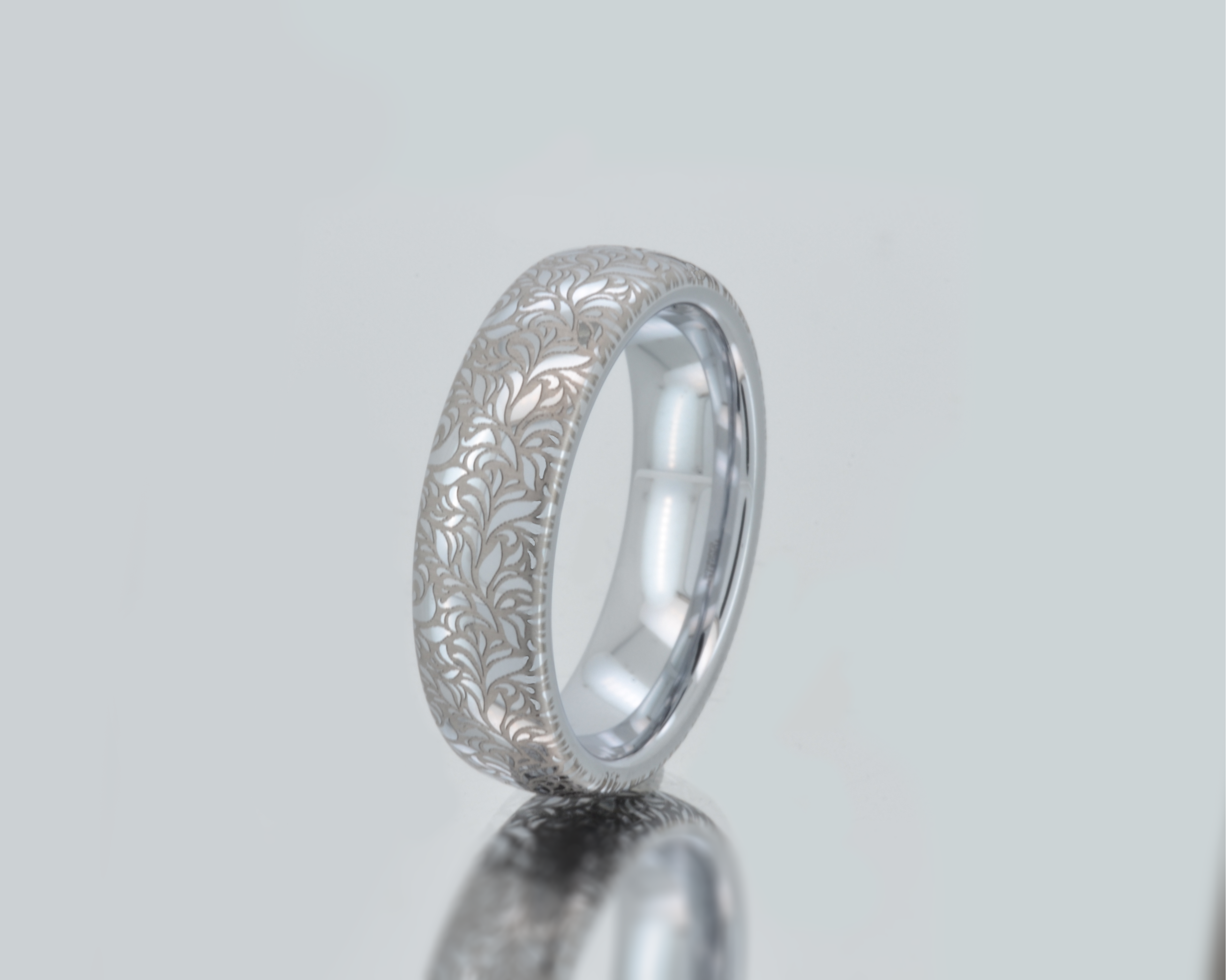 Elegant white gold tungsten with intricate silver floral engraving, featuring a polished shiny finish and delicate patterns. Durable and stylish, this engraved tungsten wedding or engagement band for her or him