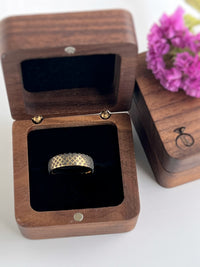 Product photo of the The Regal Weave tungsten ring with laser-engraved surface detail.