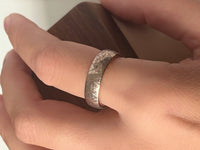 Petal Dance tungsten ring with laser-engraved surface detail, worn on a hand.