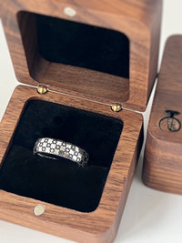 Product photo of the Chain of Unity – Black Engraving tungsten ring with laser-engraved surface detail.