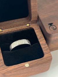 Product photo of the Floral Reverie tungsten ring with laser-engraved surface detail.