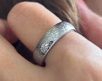 Floral Reverie tungsten ring with laser-engraved surface detail, worn on a hand.
