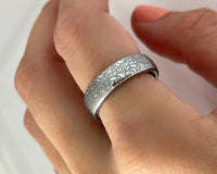 Product photo of the Floral Reverie tungsten ring with laser-engraved surface detail.