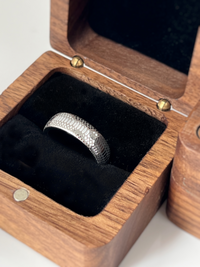 Product photo of the Serpente Eterno tungsten ring with laser-engraved surface detail.