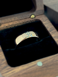Product photo of the Om Harmonie tungsten ring with laser-engraved surface detail.