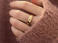High Polished Rose Gold Tungsten Wedding Band with a polished plain surface, worn on a hand.