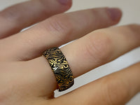 Golden Mokume Majesty tungsten ring with laser-engraved surface detail, worn on a hand.