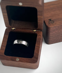 Product photo of the The Arrow Waves tungsten ring with laser-engraved surface detail.
