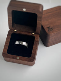 Product photo of the The Labyrinthine Loop tungsten ring with laser-engraved surface detail.