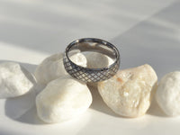 Product photo of the White Gold Quilted Elegance tungsten ring with laser-engraved surface detail.