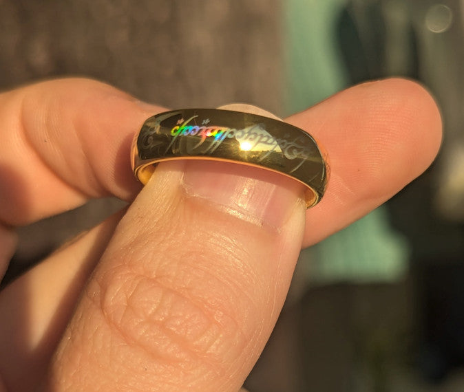 Produktová fotografie holografického prstenu Holographic Inscription z karbidu wolframu s laserově vytvořeným holografickým povrchovým efektem.