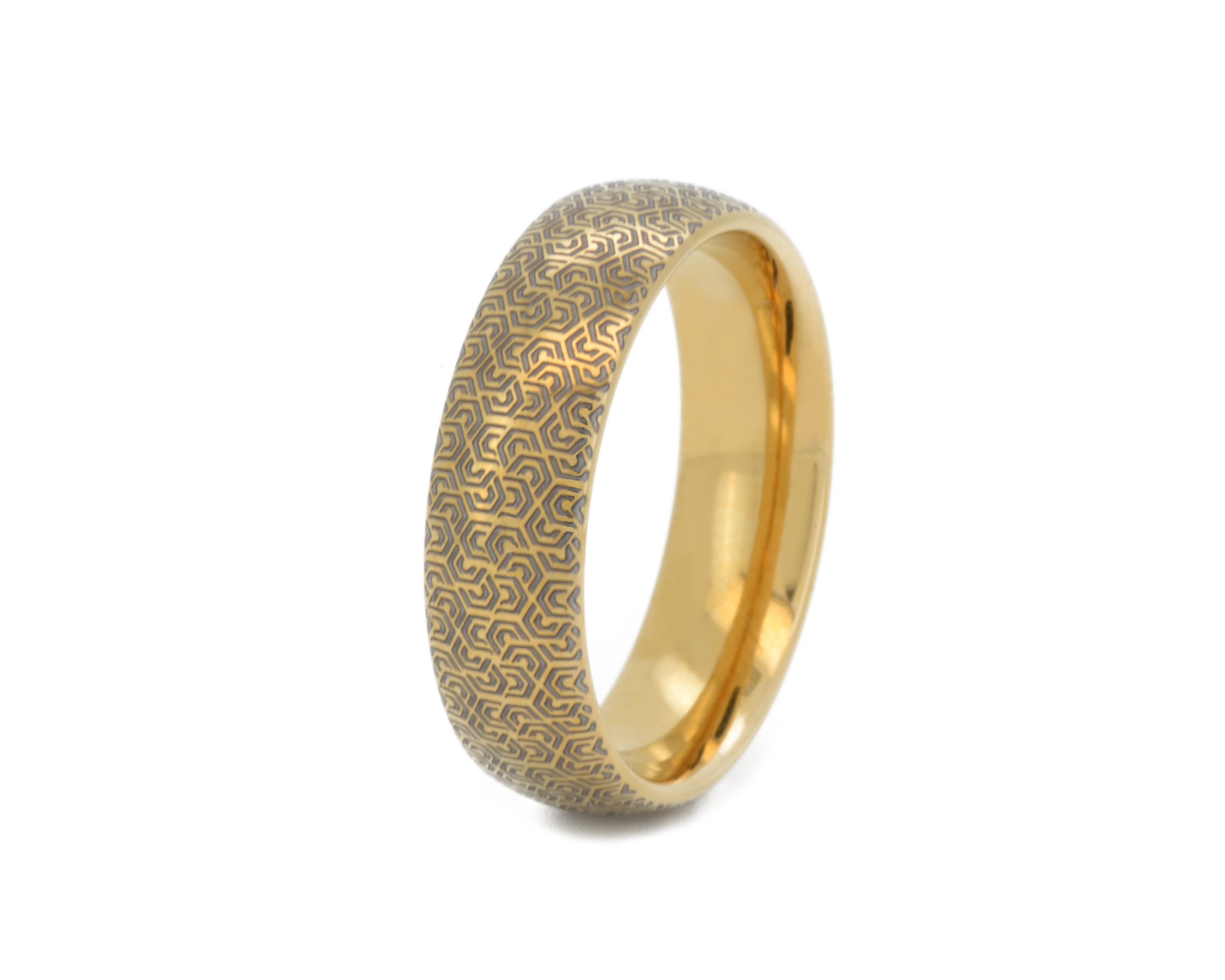 Gold ring with intricate design on a white background