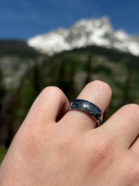 Product photo of the Mountains tungsten ring with laser-engraved surface detail.