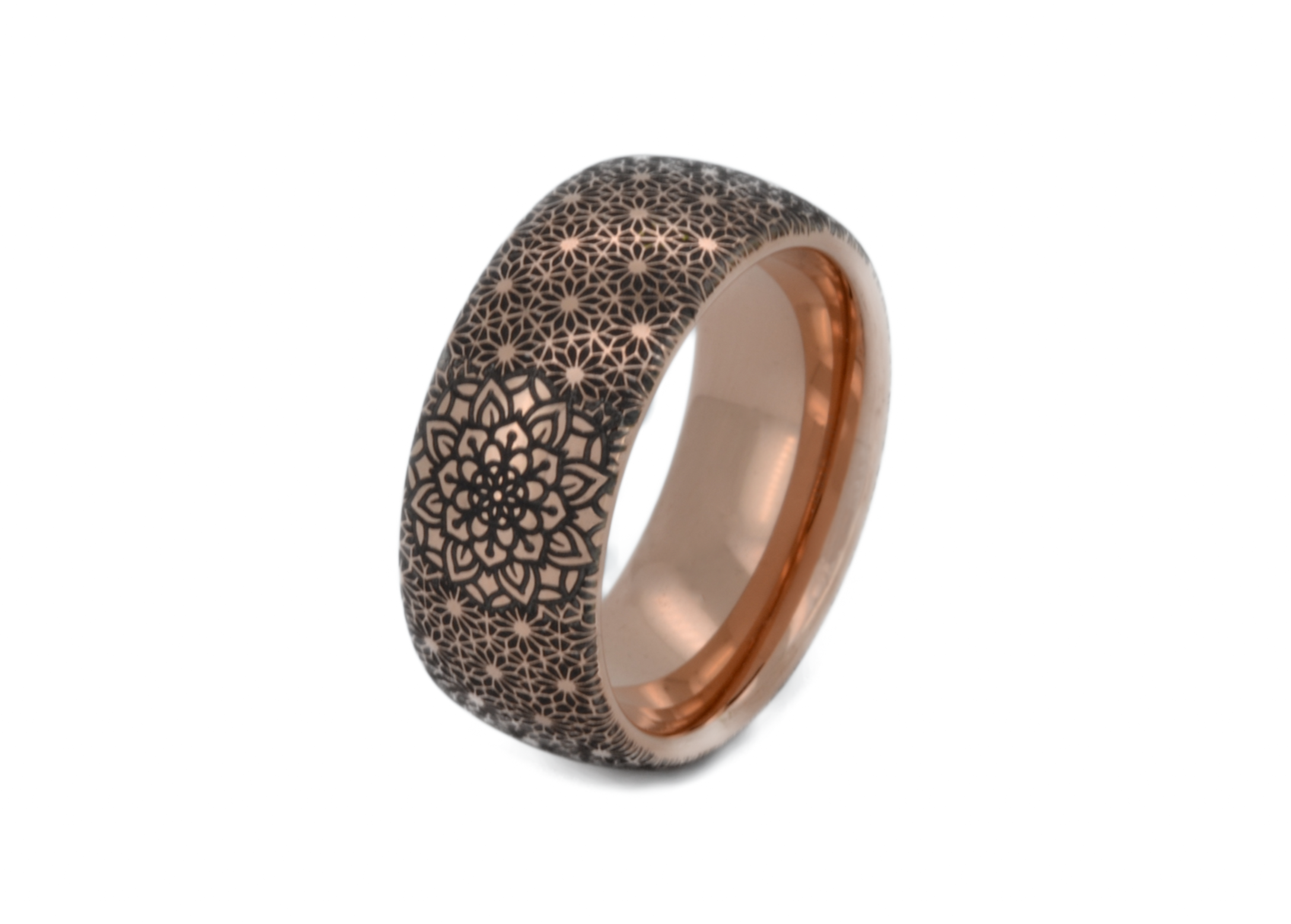 Rose gold tungsten ring with a detailed boho floral mandala pattern engraved on the exterior and a contrasting rose gold interior, isolated on a white background.