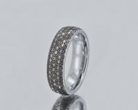 Silver ring with geometric pattern on a gray background