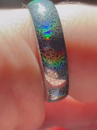 Macro video of the Baroque Radiance ring on a finger, showing the ornamental pattern changing color with the viewing angle.