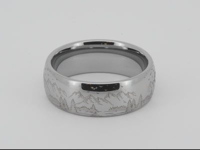 Silver tungsten ring with an engraved mountain range design, isolated on a white background.