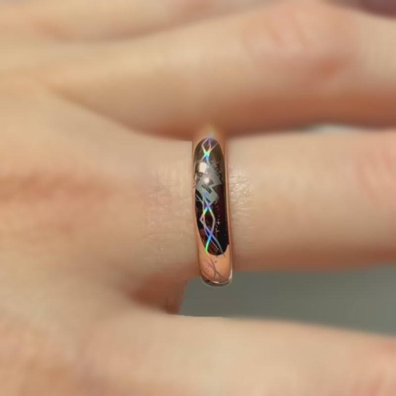 Video of a rose-gold Heartline ring worn on a finger, with colorful geometric heart lines shifting in the light.