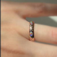 Video of a rose-gold Lotos Glow ring worn on a finger, with colorful lotus petals shifting in the light.